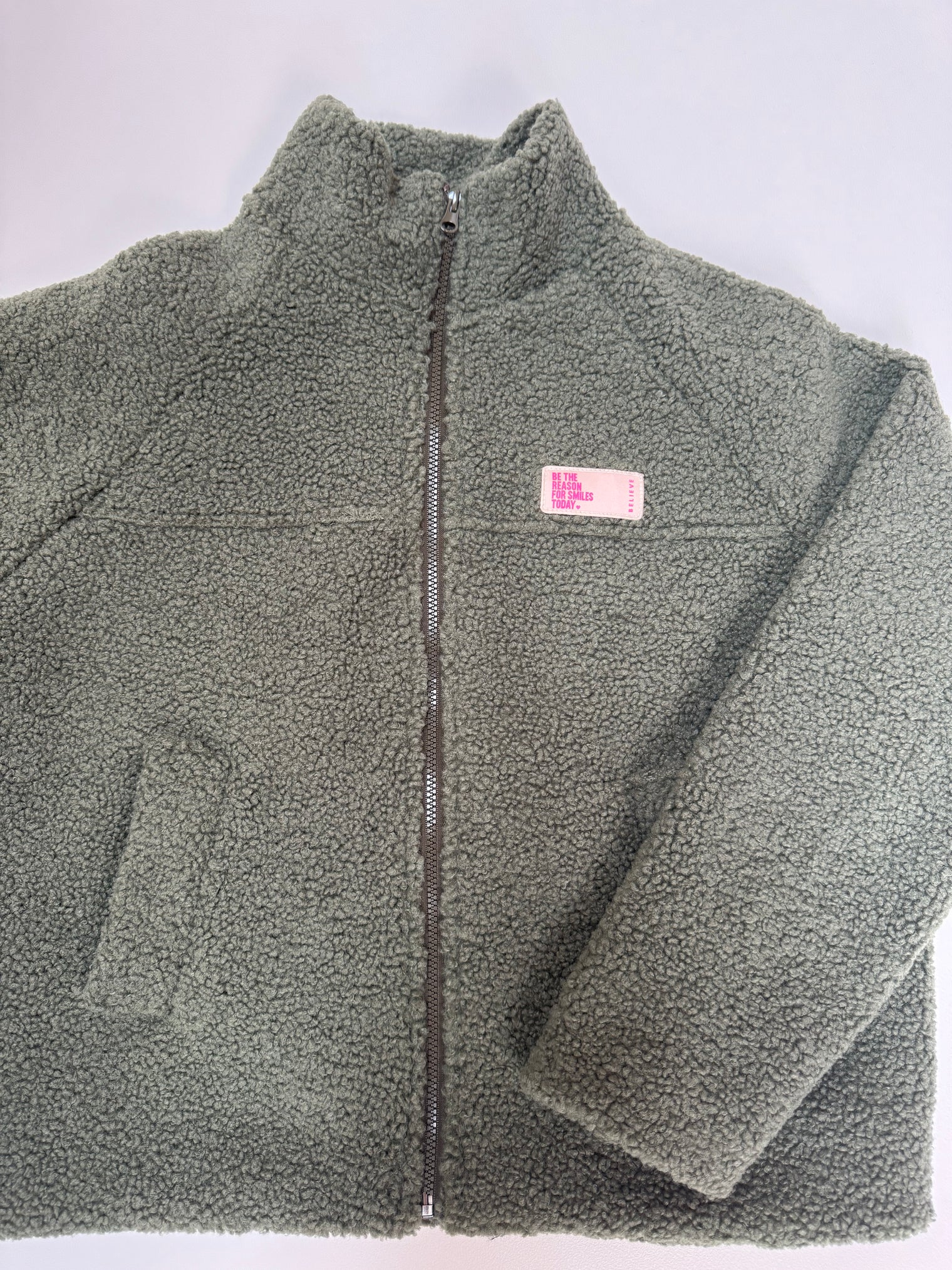 Kuschel Jacke mit Reißverschluss & Patch BE THE REASON FOR SMILES TODAY grün